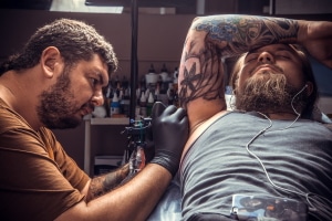 Anzeige wegen Körperverletzung: Ein Tattoo muss trotz Einwilligung bestimmte Anforderungen erfüllen.